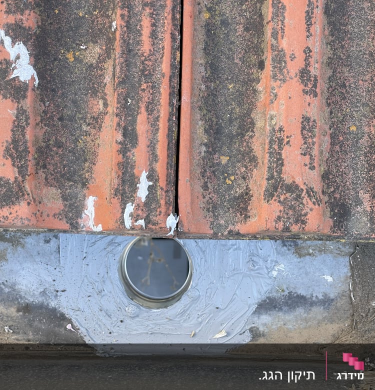 רעפים ישנים עם חלודה וחור עגול במרכז